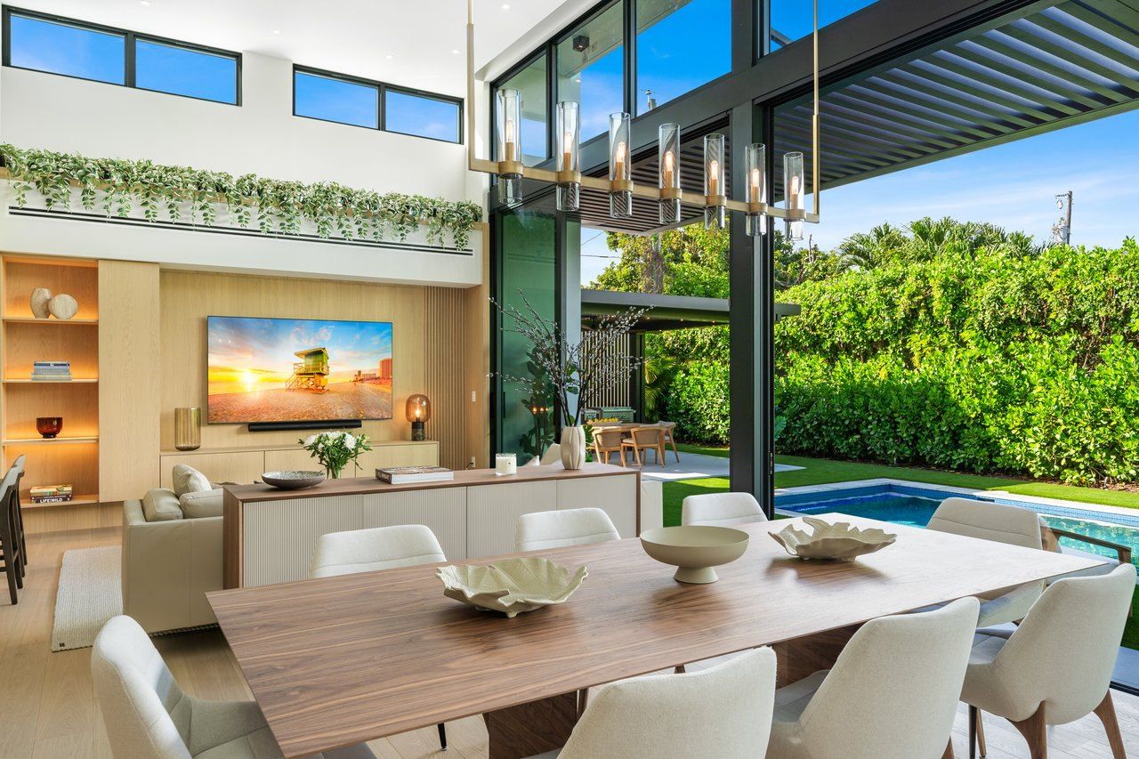 Dining area under a double-height ceiling with views to the garden